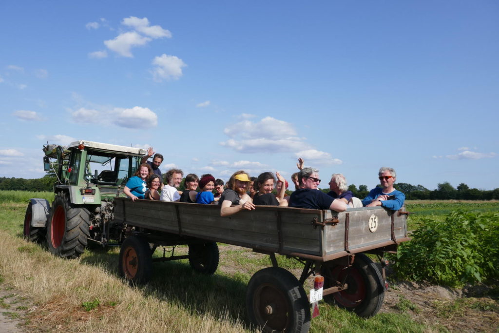 Hofrundfahrt im Trecker - die Gruppe sitzt hinten drauf und erkundet die Landwirtschaft